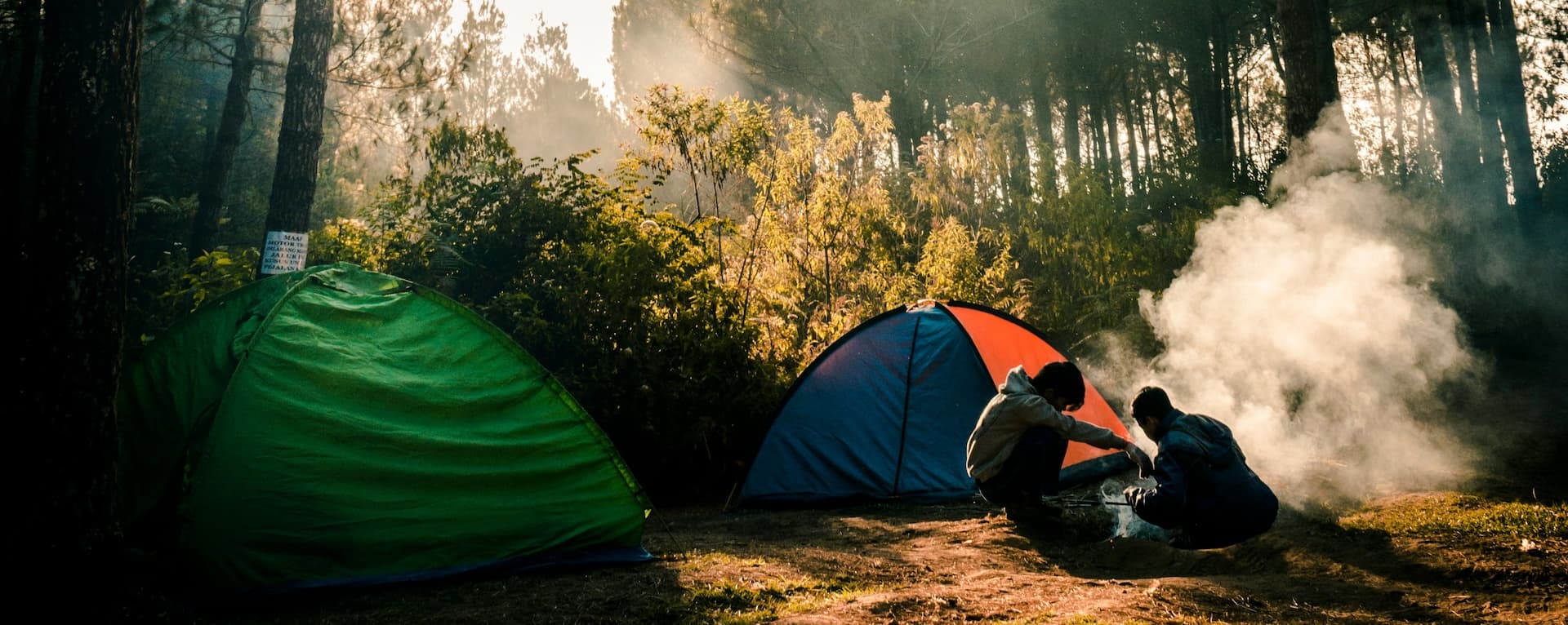 Image of people camping outside overlooking a lake